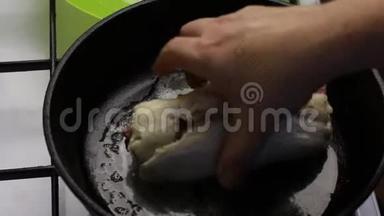 一块黄油在<strong>预热</strong>的锅里融化。 一个男人在上面放了一个鸡肉卷。 四面煎炸